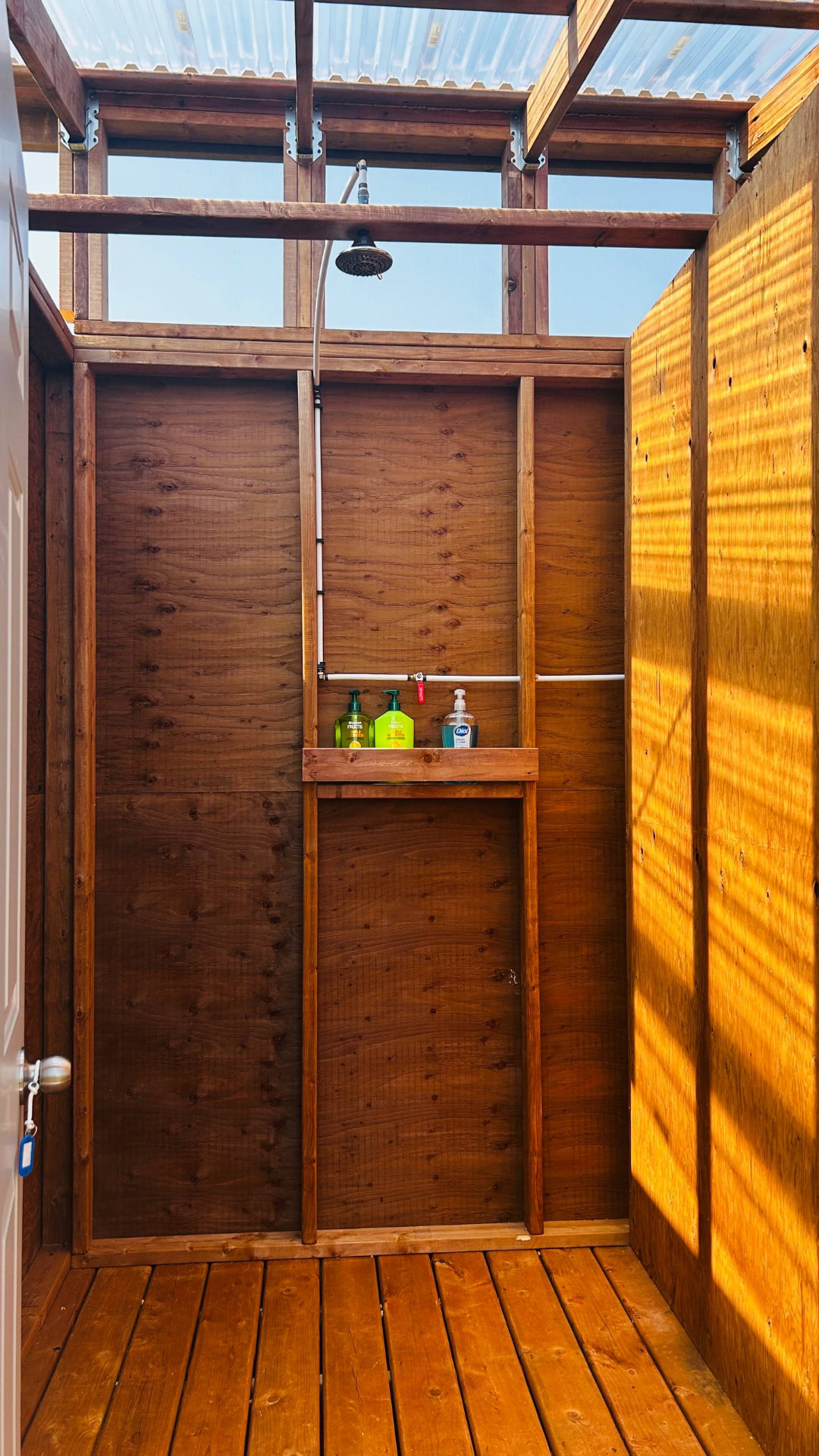 Interior of the Nature Sunroof shower facility with a rain shower head and translucent roof panels